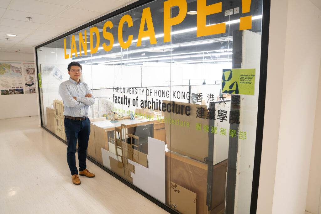 Professor Bin Chen poses with a sign for the Department of Landscape Architecture and HKU