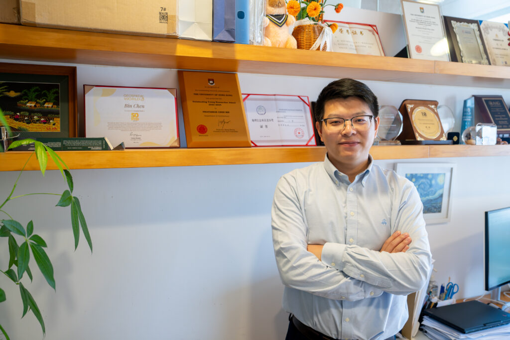 Professor Bin Chen, an expert on satellites and urban intelligence, poses with some of his awards