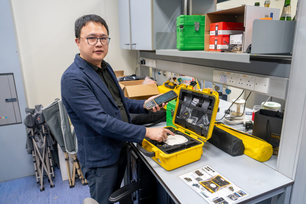 Professor Jin Wu shows off some of the equipment he uses to monitor changes in forests.